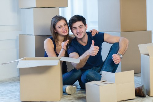 Professional movers carrying furniture in a Fulham flat building