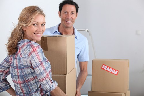 Professional movers carrying furniture through a Fulham townhouse hallway